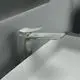 Armatur von Ideal Standard in Silber mit einem schlanken Design, montiert am Rand eines ovalen Waschbeckens. Der Wasserhahn hat eine flache, breite Auslaufkante.